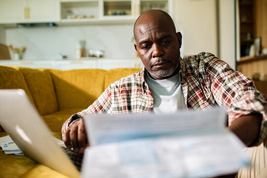 Mature man reviewing household bills at home