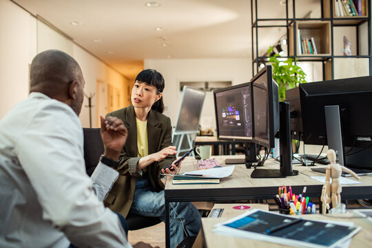 Coworkers discussing design project at modern creative office