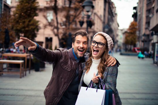 Happy couple shopping on city street in autumn