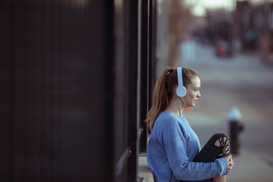 Young woman listening to music with headphones on a city street