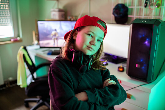 Confident tween gamer with headset at home gaming desk