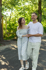 Fototapeta premium Happy couple walking together on a sunny day in a park, enjoying each other's company