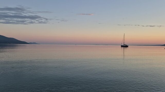 Albania showcases stunning views of Orikum as the sun sets behind the tranquil waters and impressive mountains. This picturesque moment invites relaxation and appreciation for natures beauty.