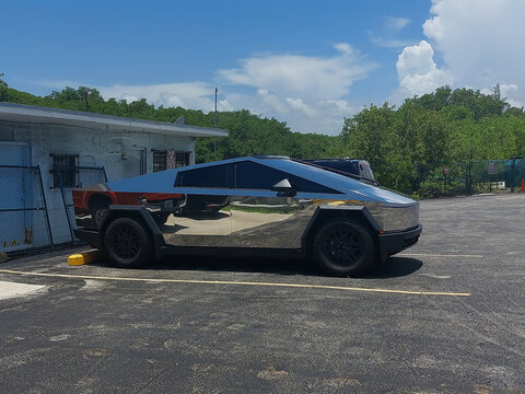 Futuristic Automotive Design: Chrome Mirrored Tesla Cybertruck Parked Under Bright Sunlight in Florida