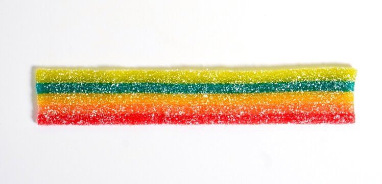 Colorful sour and sweet sugar coated candy jelly strip isolated on horizontal white background.