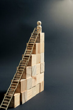 Wooden figurine reaching the top of a staircase as a symbol of career growth and business success