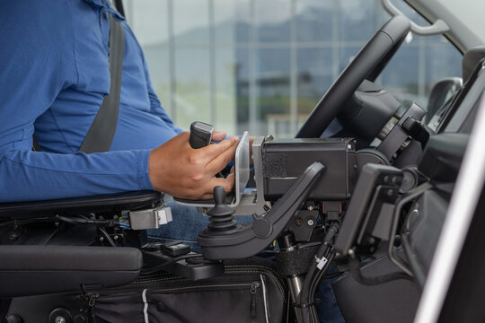 Person with disability using assistive driving technology in an adaptive vehicle to enable mobility and transportation independence, close-up.
