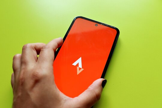 Salvador, Brazil - July 17, 2026: Woman hand holding a smartphone displaying the Strava application on the screen. Fitness tracking and physical activity.