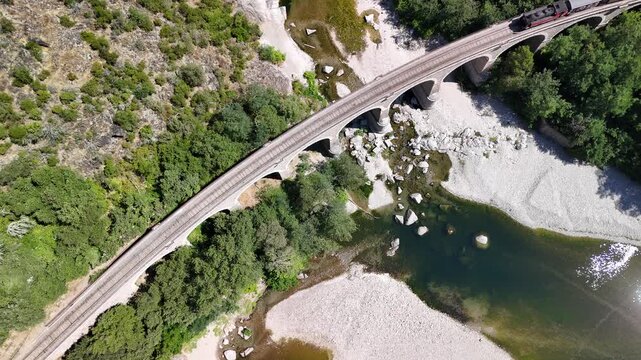 Aerial View of Historic Steam Train Crossing Stone Railway Viaduct near Anduze, France