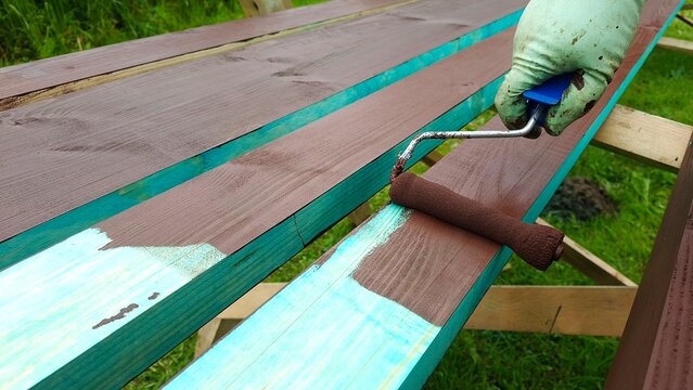 Wooden surface being coated with protective paint