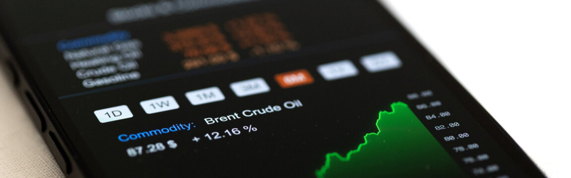 Rising Brent Crude oil chart and energy commodity data on smart phone screen. Commodity investment, natural gas and heating oil future contracts, trading, wireless technology.