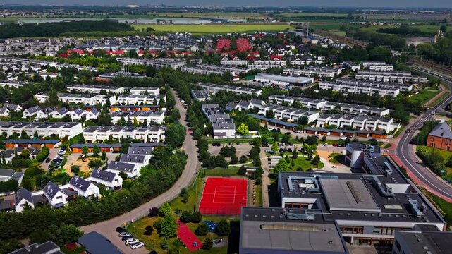 Suburban Residential Estate Aerial Drone View School Building Road Traffic. High angle panoramic drone shot contemporary housing development district featuring white family houses, a primary school