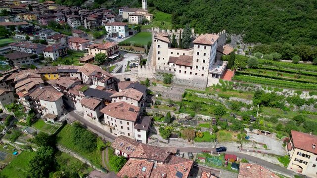 Castello di Tenno Italy Aerial Drone Flight Approach Orbit Medieval Castle Borgo Village and Alps Mountain Landscape Scenic Lake Garda Reveal Background Summer Travel Video 4K