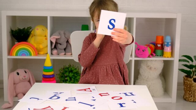 The child learns English letters. Selective focus.