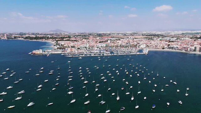 Aerial view of boats moored at the marina in Los Alcazares along the Mar Menor coast. Coastal tourism and marine leisure concept for Mediterranean travel advertising.

