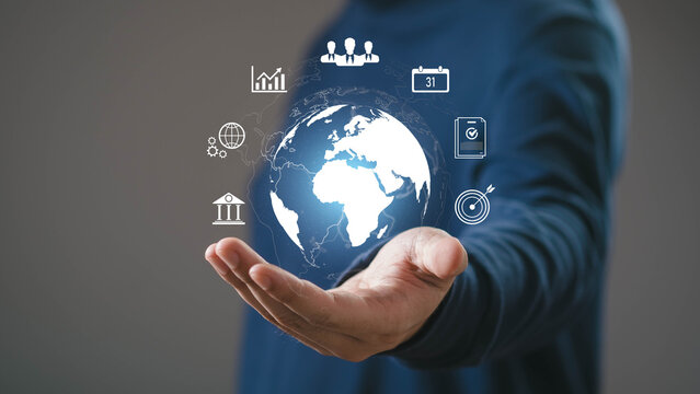 Business hand holding digital globe with global business icons representing international management, corporate strategy, worldwide communication, finance, technology, and global network solutions.