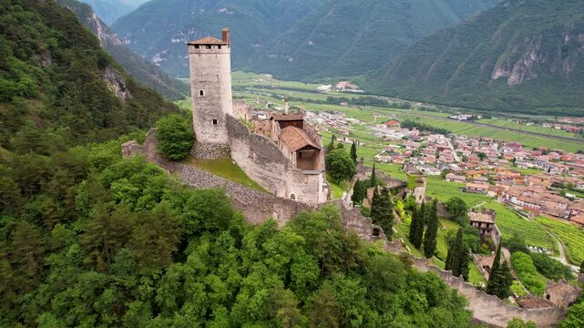 Avio Castle Trentino Italy 4K Drone.  aerial flight over ruined medieval fortress on hilltop. Green forest mountain valley and village landscape b roll cinematic travel stock video asset