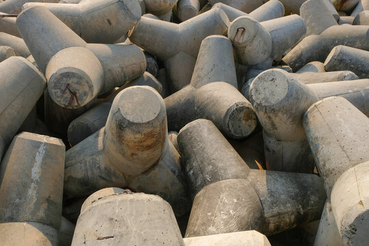 Close-up texture of stacked concrete tetrapods used for coastal defense and breakwater protection. Marine infrastructure. Shoreline erosion control, wave protection, and engineering concept