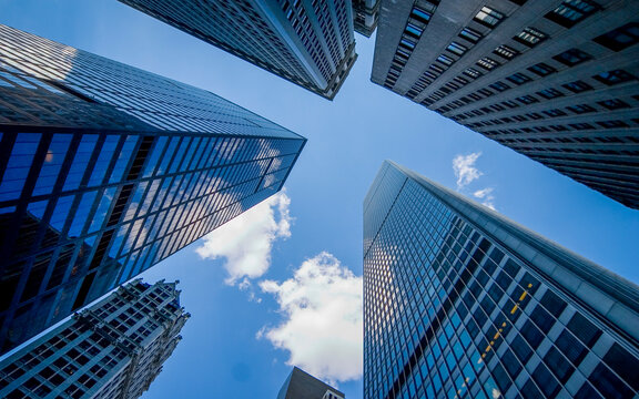 Downtown Manhattan skyscrapers. Low angle view of modern glass towers framing blue sky in NYC.