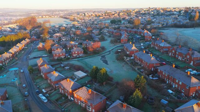 Drone's-eye winter view captures Dewsbury Moore Council estate's typical UK urban council-owned housing development with red-brick terraced homes and the industrial Yorkshire. Working class housing