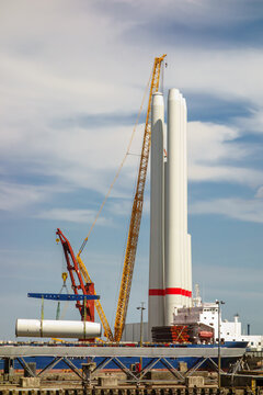 Giant Crawler Crane Assembling Wind Turbine Tower Sections at Port Harbor, Sustainable Offshore Renewable Energy Construction and Logistics