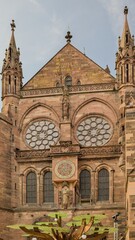 Fototapeta premium The majestic facade of Strasbourg Cathedral features unique historic clocks.