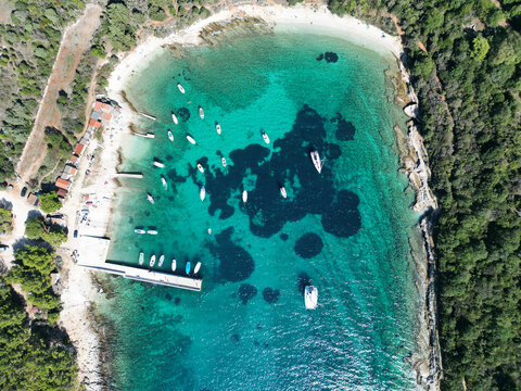 Aerial top-down view of turquoise bay with anchored boats, Kamenjak, Istria, Croatia