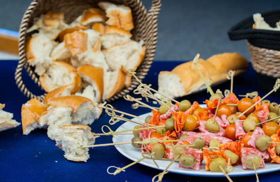 Tabla de aperitivos con brochetas de embutidos, aceitunas, tomates cherry y pan para catering y eventos