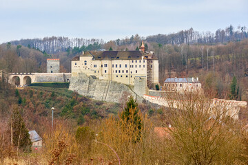 Historic castle on hillside surrounded by autumn trees and rolling hills © Iurii Gagarin