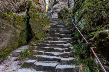 Ancient stone stairway through mossy rocky passage in nature © Iurii Gagarin