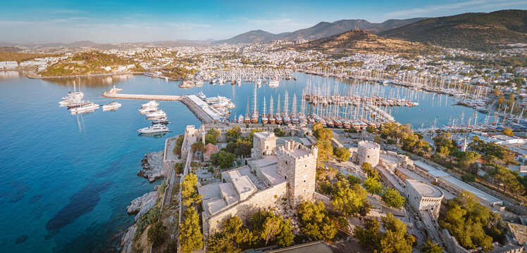 Bodrum Castle standing proudly next to the busy marina filled with numerous yachts and boats, capturing the popular Turkish resort town