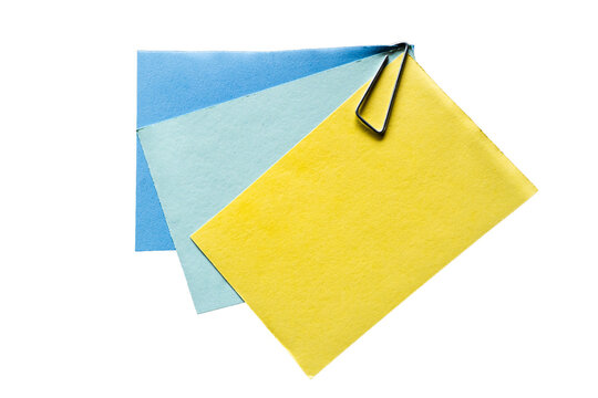 Conjunto de notas adhesivas de colores sujetas con clip met&aacute;lico sobre fondo transparente para organizaci&oacute;n y planificaci&oacute;n