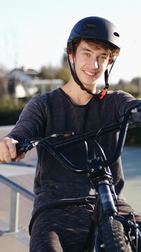 BMX rider hold up the bicycle with smile on face