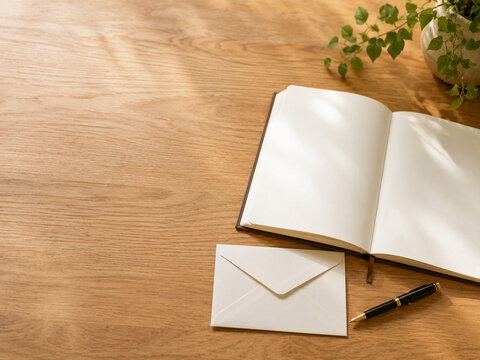 Blank ending notebook with envelope and pen on a warm wooden table