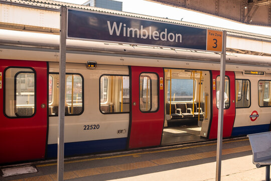 LONDON -  Wimbledon Underground Station &ndash; District line train at the platform with station sign, Zone 3.