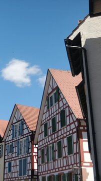 Traditional german half-timbered houses fachwerkhaus architecture on a beautiful sunny summer day with a clear blue sky and a single white cloud floating peacefully