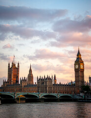Fototapeta premium Houses of Parliament at sunset. Dramatic sky over Big Ben and Westminster Bridge reflected in the River Thames, London.