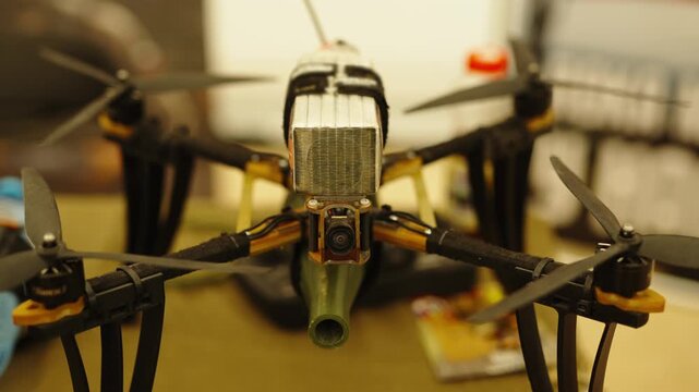An FPV racing quadcopter drone carrying a large LiPo battery pack secured with a strap on top.