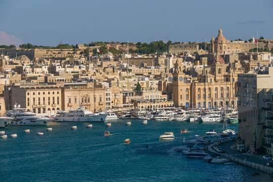 Vista panor&aacute;mica del Gran Puerto de Malta, repleto de yates de lujo y barcos, con la hist&oacute;rica ciudad de Vittoriosa y sus iglesias al fondo.