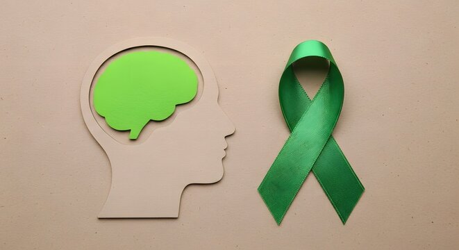 Mental health awareness concept with brain and green ribbon. Human head silhouette showing brain activity and support symbol. Healthcare and wellne...