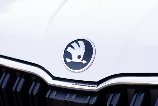 Kyiv, Ukraine. July 17, 2026. Close-up of a silver Skoda car logo emblem on a white glossy vehicle hood above the front grille.