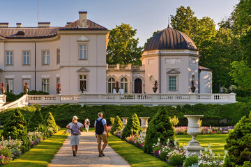 Obraz premium Tourists walking in a beautiful botanical garden in front of Tiskeviciai Palace in Palanga, Lithuania.