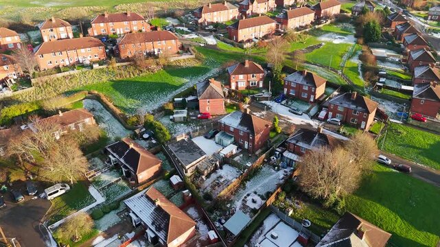 Drone's-eye winter view captures Dewsbury Moore Council estate's typical UK urban council-owned housing development with red-brick terraced homes and the industrial Yorkshire. Working class housing
