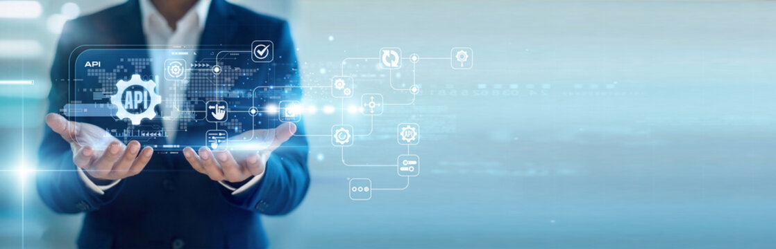 Software engineer handhold virtual screen for API integration while working on laptop to connect services. Seamless backend communication and synchronized software development architecture.