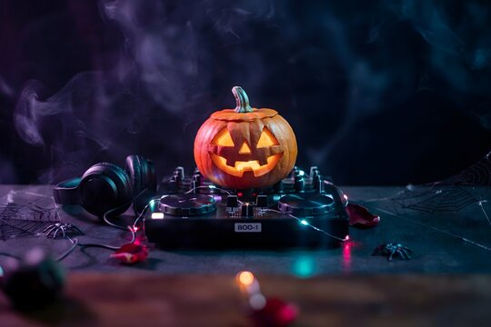 Halloween dj setup jack o' lantern on turntable with headphones spooky party music concept