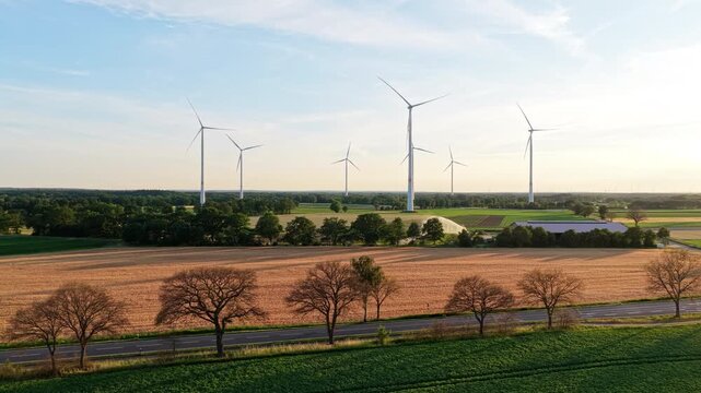 Agricultural harvest. Crop cultivation. Wind turbines farm. Green energy. Wind mill renewable electric energy production. Wind mill for renewable electric energy production. Windmill in rural area