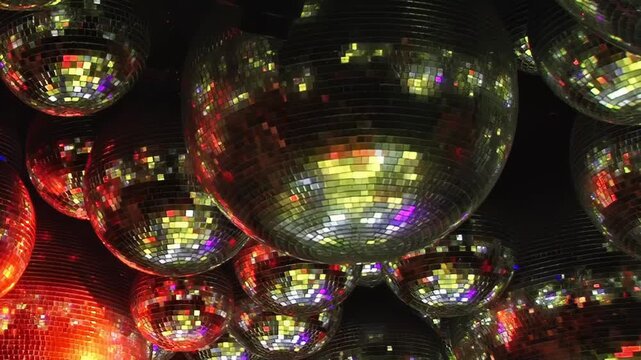 Dazzling birthday bash illuminates disco night. Mirrored balls reflect brilliant red and blue hues, creating vibrant dance floor. Joyful celebration fills air as guests enjoy this special evening.