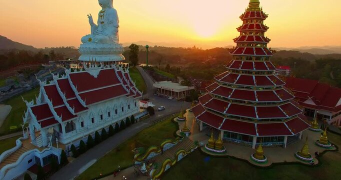 Aerial view amazing the biggest Guanyin in the world in sweet sunset. beautiful white church infront of the biggest Guan Yin statue in Chinese temple style. Wat Huay Pla Kang at Chiang Rai Thailand.