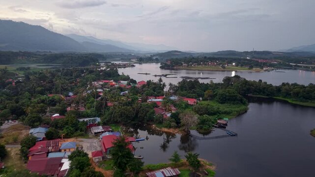 Aerial view of village with red roofs beside a calm river at Tasik Raban