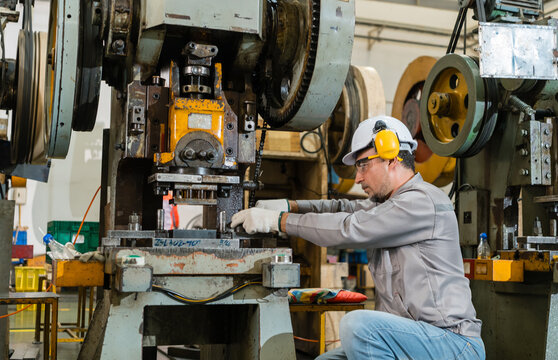 Male Operator Tightening Bolt On Power Press Die During Maintenance